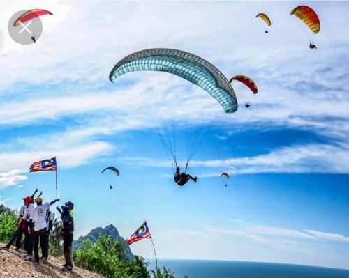 een groep mensen op een heuvel met een parachute bij Adam Homestay Besut in Kampung Raja