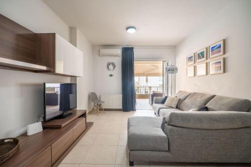 a living room with a couch and a television at City Beach Apartment in Chania Town