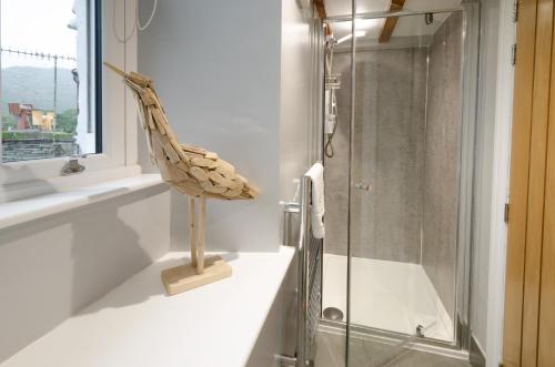 a bathroom with a shower and a statue of a fish at Cherry Tree Cottage in Chapel Stile