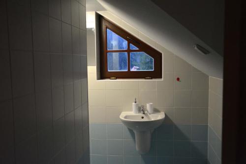 a bathroom with a sink and a window at Penzión Dinda in Stará Ľubovňa