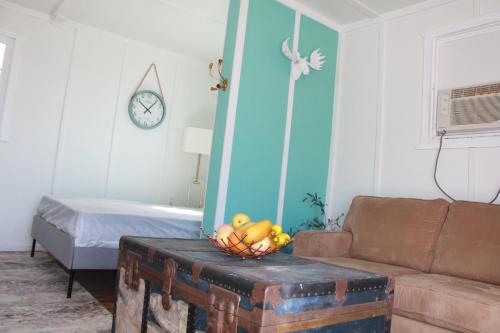 a room with a couch and a basket of fruit on a trunk at The Lake House, Couples Retreat! in Red Bay