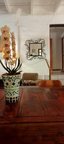 a vase with flowers on a table in a room at The Farmhouse B&B in Stellenbosch