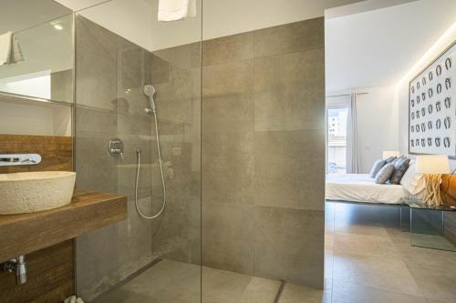 a bathroom with a shower and a sink and a bed at GRAND TERRACE APARTMENT in Puerto de Alcudia in Alcudia