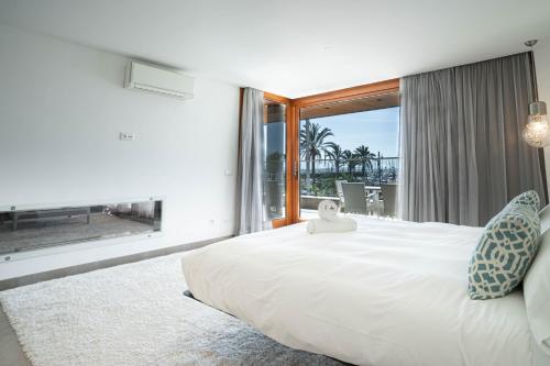 a bedroom with a large bed and a large window at GRAND TERRACE APARTMENT in Puerto de Alcudia in Alcudia