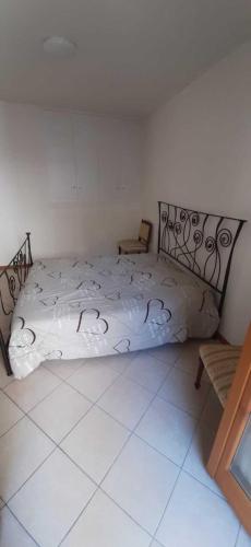 1 dormitorio con cama blanca y cabecero de metal en Altopiano del sole, en Lozio