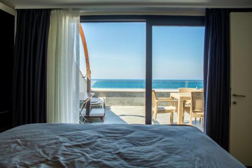 a bedroom with a bed and a view of the ocean at Duplex Loft mit Panorama Seaview in Kusadası