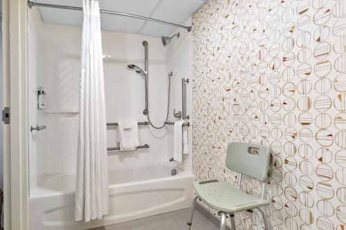 a bathroom with a shower and a chair in it at Holiday Inn Portsmouth, an IHG Hotel in Portsmouth