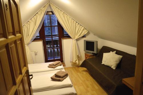 スタラー・リュボフニャにあるPenzión Dindaのベッド2台と窓が備わる小さな客室です。