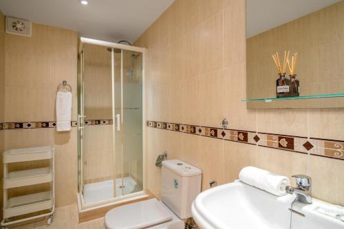 y baño con aseo, lavabo y ducha. en Don Juan apartment with pool in Carvajal Ref 98, en Fuengirola