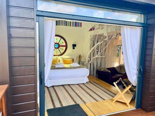 a room with a door open to a bedroom with a bed at Cabane Spa Sauna in Ville-sur-Jarnioux
