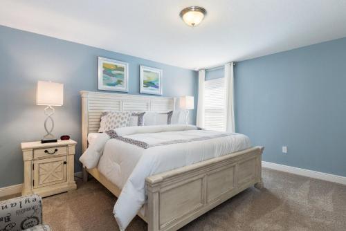 a bedroom with a white bed and a blue wall at Solterra Resort - 6 Bed SOUTH FACING Pool Home - Clubhouse, Resort Pool & Cabanas by Orlando Holiday Rental Homes LLC 5423 in Davenport