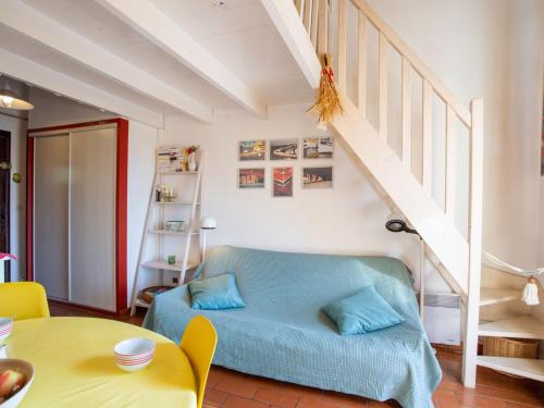 a living room with a blue bed and stairs at Apartment Les Mas de Pramousquier-1 by Interhome in Rayol-Canadel-sur-Mer