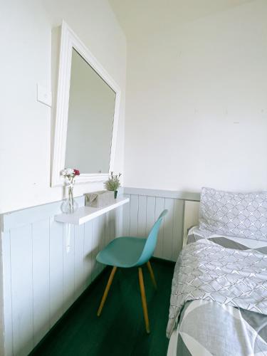 a bedroom with a blue chair next to a bed at The Satu Stay - Apartemen SGV in Tangerang