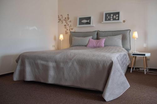 een slaapkamer met een groot bed met een roze kussen bij Steiner Strandappartements Appartement 306 Süd- Landseite in Stein