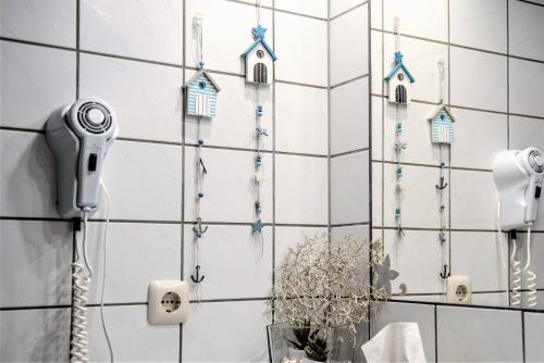 een badkamer met een telefoon op een betegelde muur bij Steiner Strandappartements Appartement 306 Süd- Landseite in Stein
