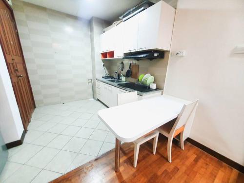 a small kitchen with a white table and chairs at [HERITAGE 7] HOMESTAY Studio 4Pax, FREE WIFI in Seri Kembangan