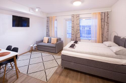 a bedroom with a bed and a chair and a window at First Aparthotel Dasher in Rovaniemi