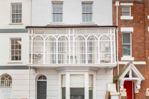 a white house with a large window at Beautiful City Centre Flat with Free Parking in Exeter