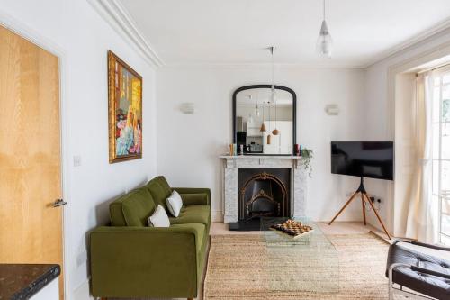 a living room with a green couch and a fireplace at Beautiful City Centre Flat with Free Parking in Exeter