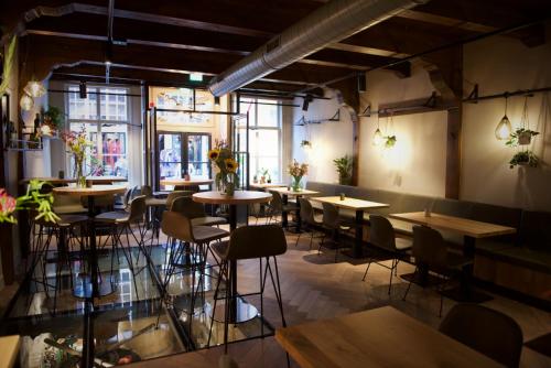 a room with tables and chairs in a restaurant at Hotel 't Fnidsen in Alkmaar