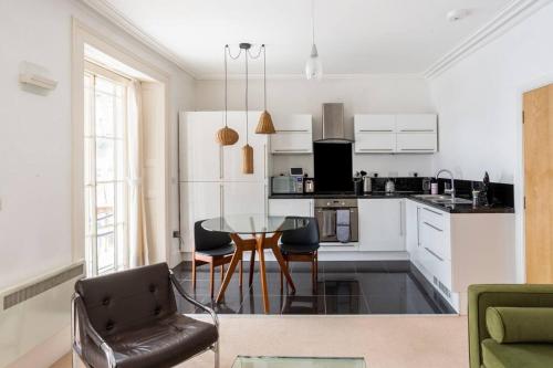 a kitchen with a table and chairs in a room at Beautiful City Centre Flat with Free Parking in Exeter
