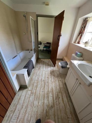 a bathroom with a tub and a sink and a bath tub at Delightful Pretty Cottage in Banbury