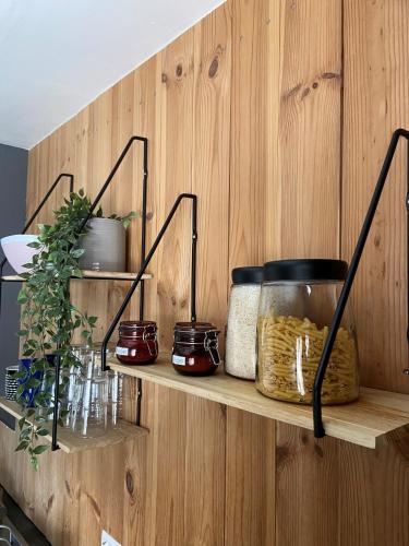 a wooden wall with shelves with jars and plants at The Little Guesthouse Downtown - Keflavik Airport in Keflavík