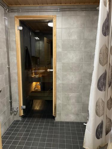 La salle de bains est pourvue d'une douche et d'une porte en verre. dans l'établissement Ruka, Kelokaltiokylä, Mökki 28, à Ruka