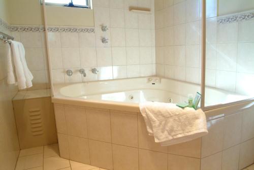 a bathroom with a bath tub and a towel at Victoria Hotel Strathalbyn in Strathalbyn
