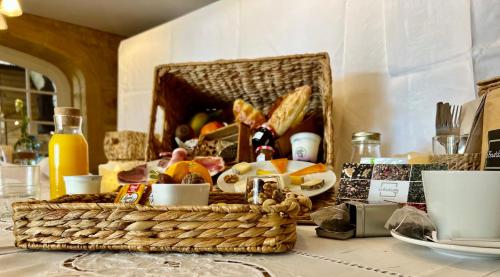 - une corbeille de pain et de fruits sur une table dans l'établissement Cabane Spa Sauna, à Ville-sur-Jarnioux