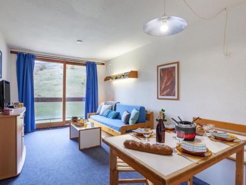 un salon avec un canapé bleu et une table dans l'établissement Studio Lunik Orion-12 by Interhome, au Corbier