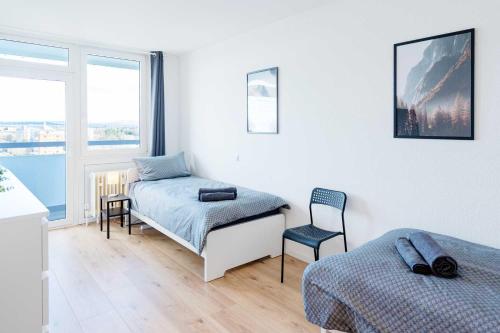 a bedroom with two beds and a chair in it at Chic City-View Apartments in Hanau in Hanau am Main