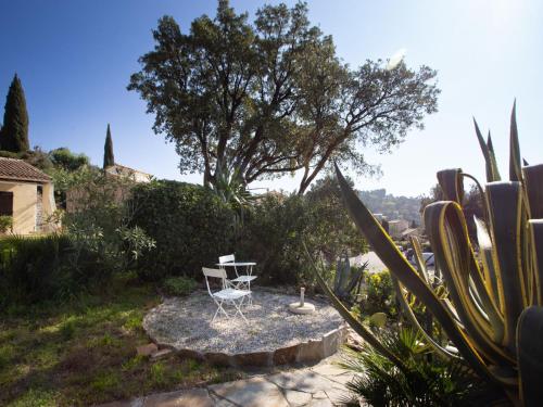 a chair sitting on a table in a garden at Holiday Home Les Mas de Pramousquier-2 by Interhome in Rayol-Canadel-sur-Mer