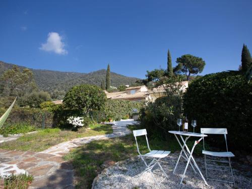 a couple of chairs and a table in a garden at Holiday Home Les Mas de Pramousquier-2 by Interhome in Rayol-Canadel-sur-Mer