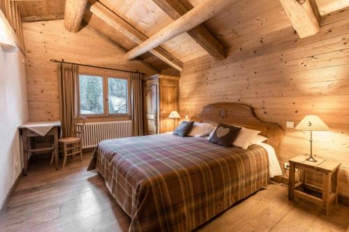 1 dormitorio con 1 cama en una habitación de madera en La Ferme du Var en La Clusaz