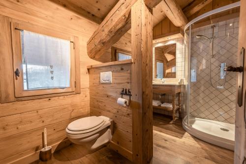 y baño de madera con aseo y ducha. en La Ferme du Var en La Clusaz