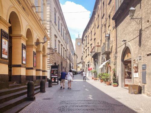 two people walking down a city street with buildings at Apartment Allerona-1 by Interhome in Allerona