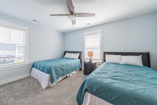 a bedroom with two beds and a ceiling fan at Kilmarlic Jones Cottage in Powells Point
