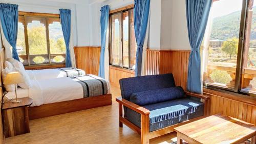 a bedroom with a bed and a chair and windows at Tshang Tshang Villa in Paro