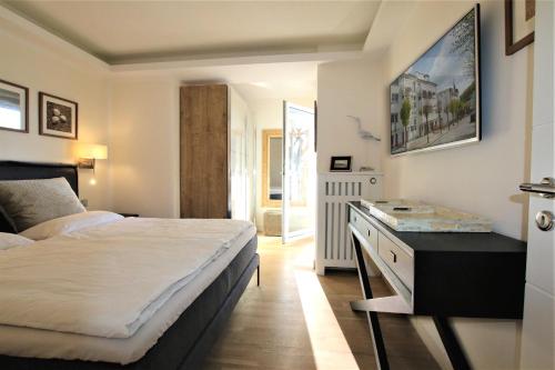a bedroom with a bed and a desk in it at Villa Allegra by Rujana in Binz