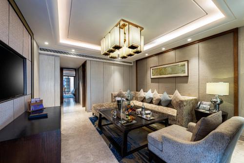 a living room with a couch and a tv at Narcissus Obhur Resort & Spa in Jeddah