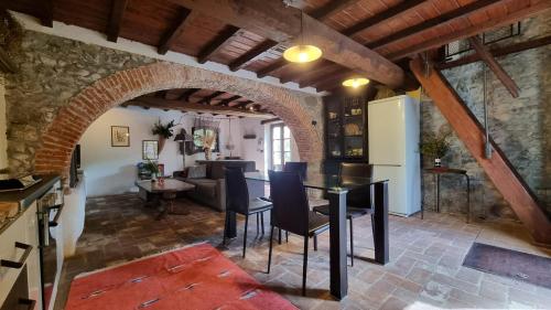 a kitchen and living room with a table and a refrigerator at Rose Cottage Tuscany in Fosdinovo