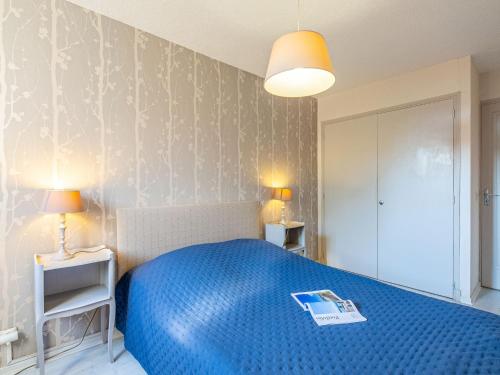 - une chambre avec un lit bleu et un livre dans l'établissement Apartment Les Sables by Interhome, à Fréjus