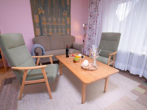 uma sala de estar com uma mesa e duas cadeiras e um sofá em Holiday Home Strandwinkel by Interhome em Norddeich
