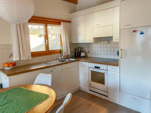 a kitchen with a table and a white refrigerator at Apartment Eva by Interhome in Schmitten