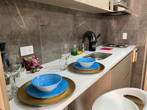 eine Küchentheke mit zwei blauen Schalen und einem Waschbecken in der Unterkunft Beautiful Loft 35 Movistar Arena - Campin - Chapinero Bogota Colombia HOSTMI in Bogotá