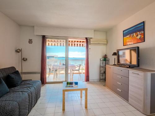 un salon avec un canapé, une télévision et une table dans l'établissement Apartment Le Capitole-3 by Interhome, à Fréjus