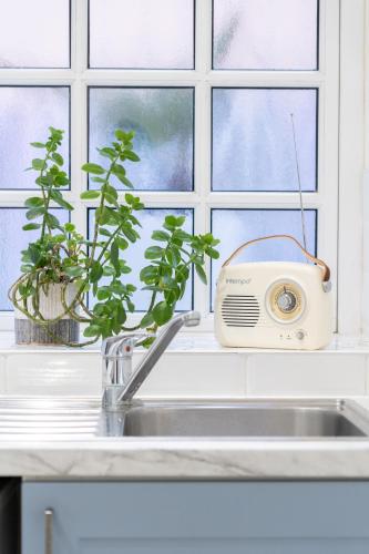 eine Küchenspüle mit einem Toaster neben einem Fenster in der Unterkunft The Pearl Suite by Margate Suites in Margate