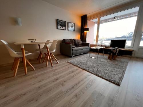 ein Wohnzimmer mit einem Sofa und einem Tisch in der Unterkunft Apartment Promenade - Utoring-60 by Interhome in Arosa