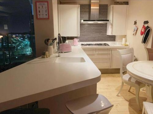 a kitchen with a white counter and a sink at Designer Penthouse with Riverviews - G1 Glasgow City Centre, 3 Bedrooms, 2 Bathrooms, 1 Living room / Kitchen. Full Floor, Wrap Around Terrace, Panoramic Views, Off Central Station / Buchanan Street in Glasgow